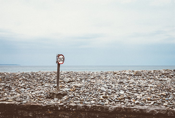 signage, speed limit, rocks, ocean, sea, water, blue