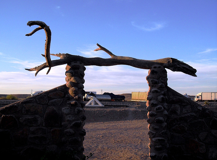 entrance, stone walls, driftwood, dry wood, sand, blue sky, late afternoon