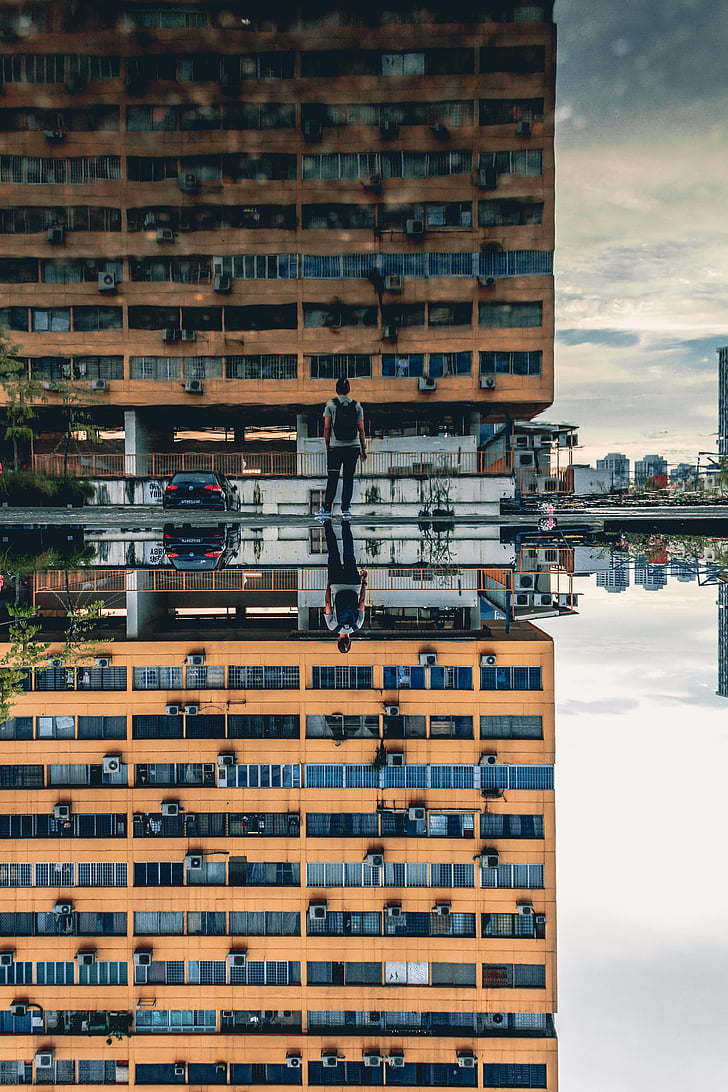 man, front, brown, high, rise, building, reflection