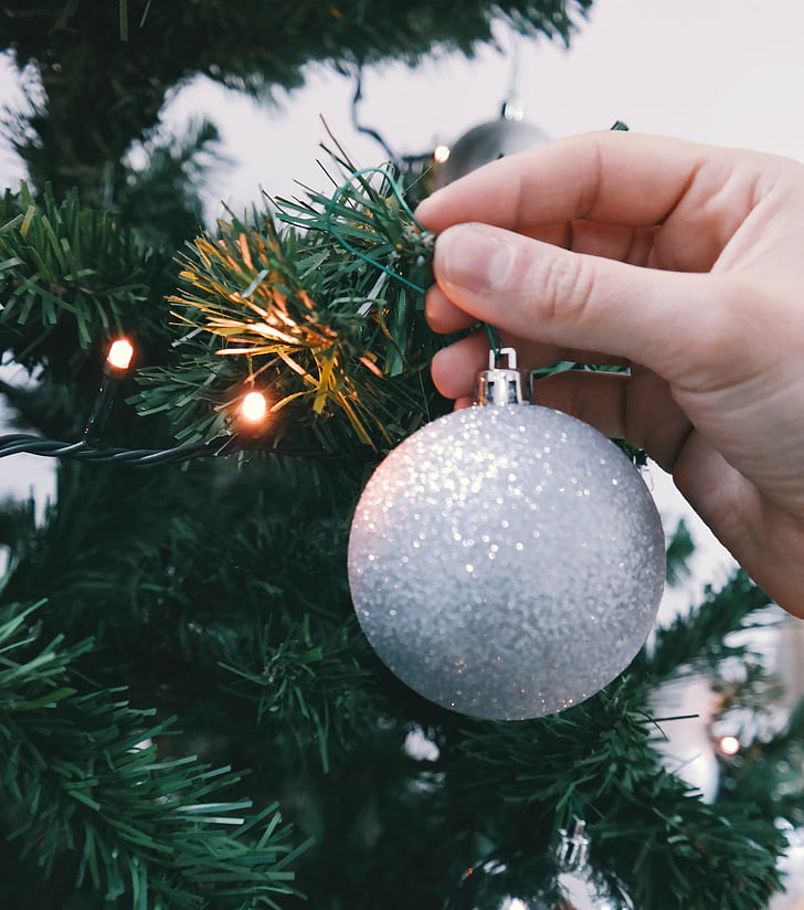 person, holding, grey, bauble, beside, green, plastic