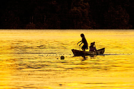 sister, evening, fish caught, dugout canoe, lagoon silhouette, widi islands, halmahera islands