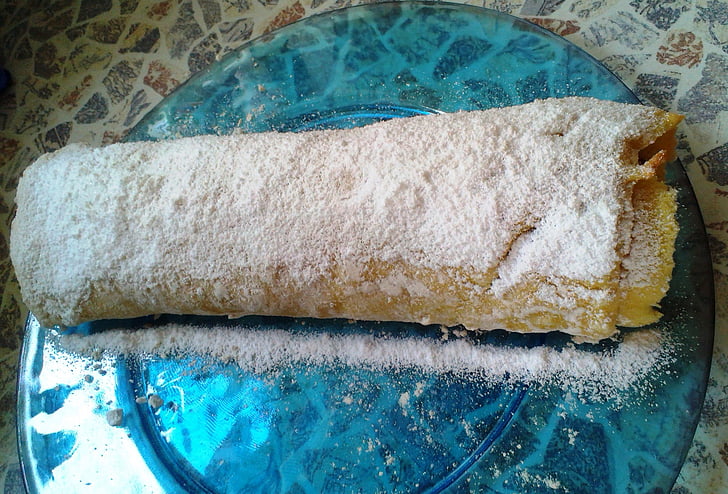 sponge cake roulade, golden brown, white powdered sugar