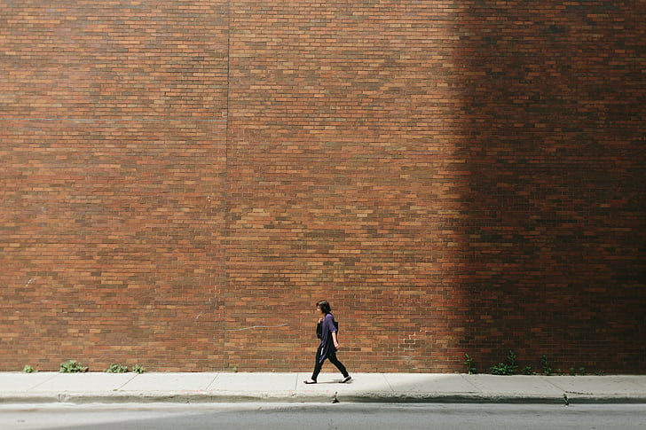 brick wall, girl, pavement, person, street, walking, wall