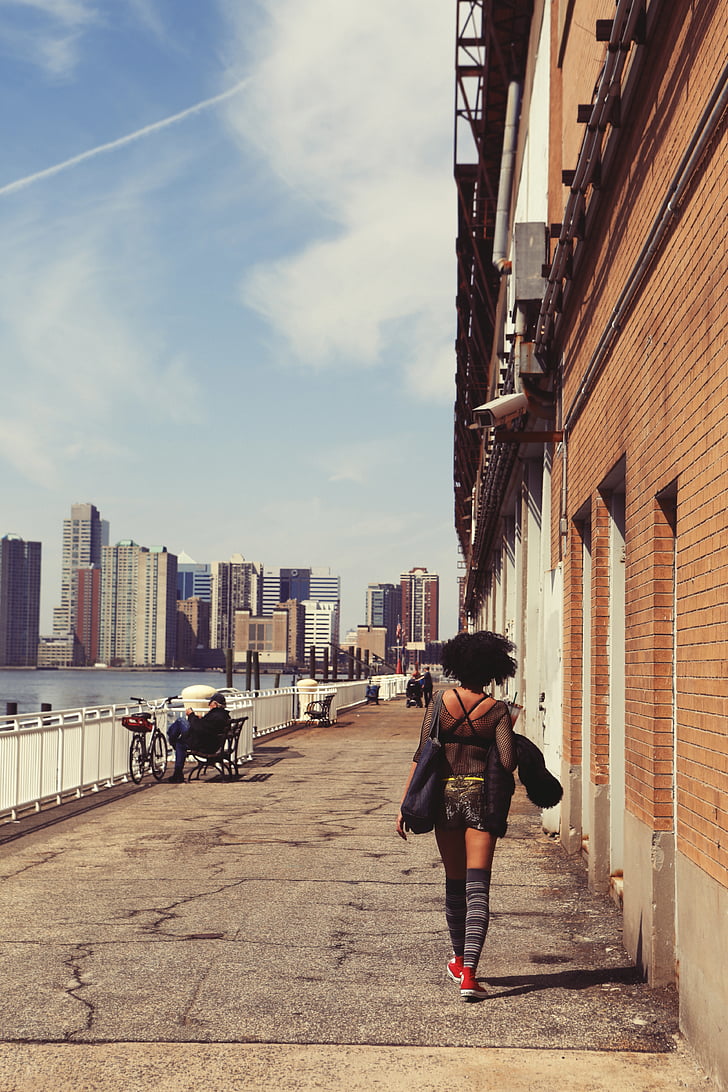 woman, black, dress, walking, alongside, brown, brick