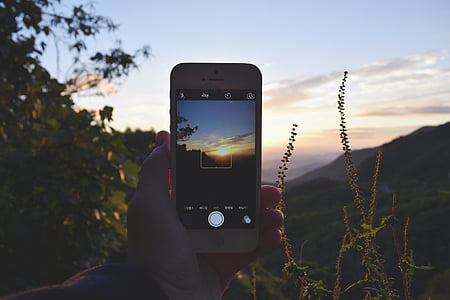 person, holding, white, iphone, taking, picture, sunset