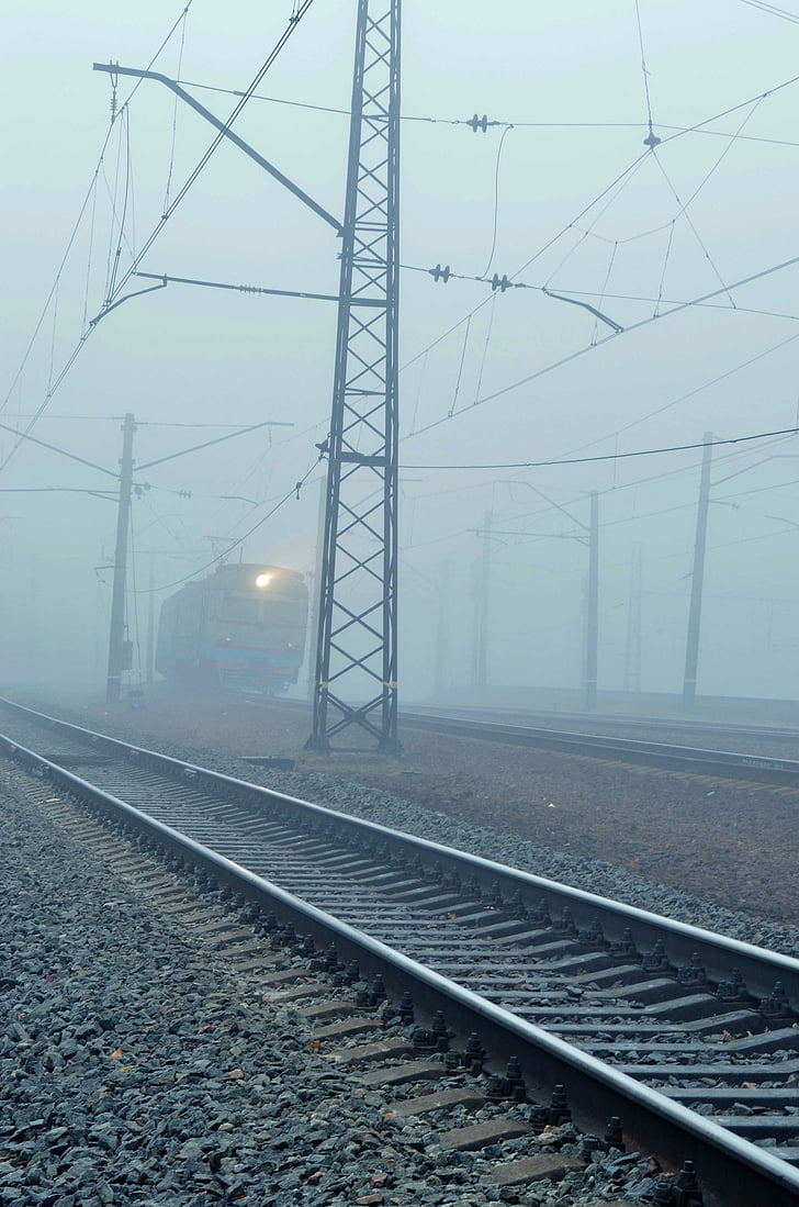 train, fog, rails, pebbles, wire, mast, light