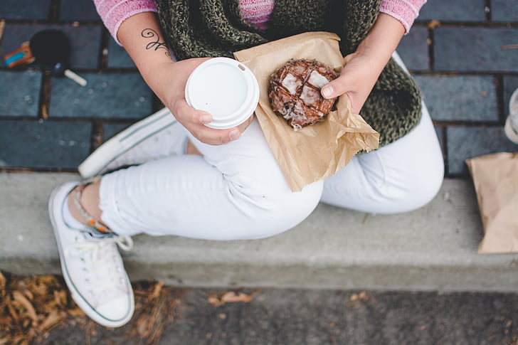 coffee cup, sitting, person, snack, hand, holding, one person