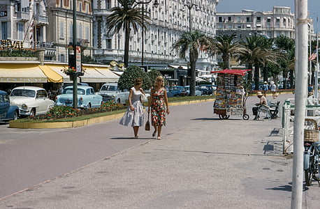 two, women, walking, street, surrounded, buildings, cars