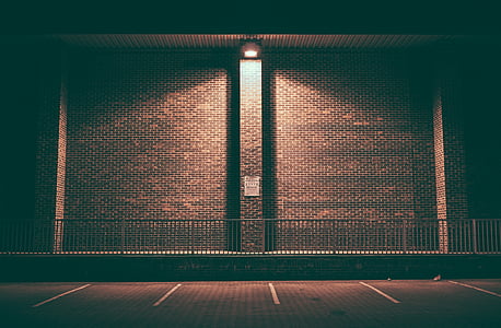 brick wall, empty, lighted, night, parking area, parking slot, parking spots