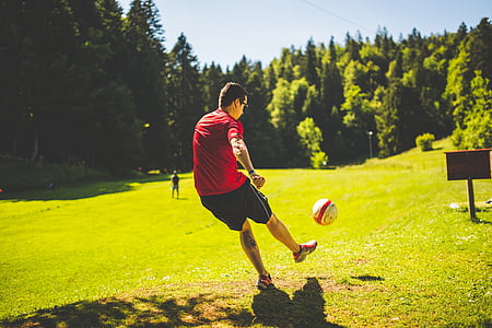 homem, vermelho, t, camisa, jogando, futebol, grama