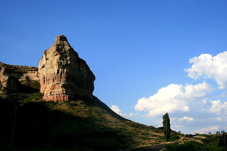 rocky outcrop, clarens region, sandstone, earthy colors, blue sky, clouds, lombardi poplar