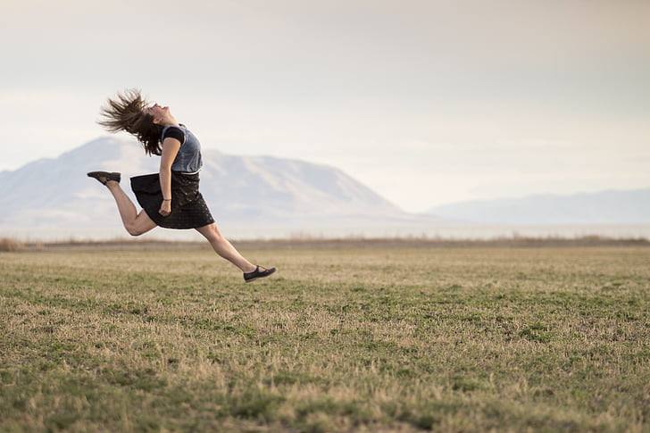 woman, black, dress, jumping, green, grass, field