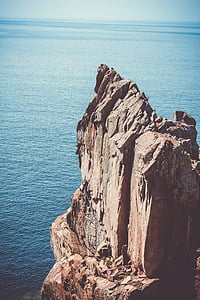 brown, rock, formation, near, body, water, sea