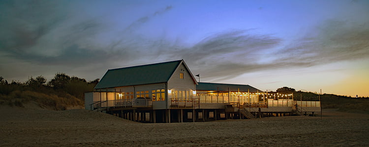 Sand, kaféet vid havet Strandhuset, Dunes, solnedgång på havet