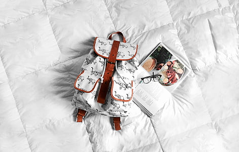 backpack, bed, book, eyeglasses, white