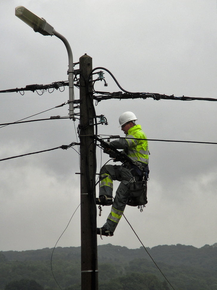 power pole, worker, electric wires, street lamp