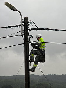 power pole, worker, electric wires, street lamp