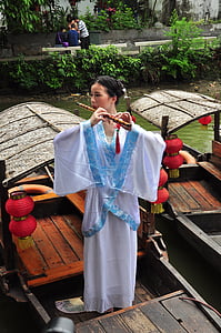 kinesisk kvinna, kinesisk kvinna med flöjt, kinesisk kvinna på båt, en kvinna endast, endast vuxna, endast kvinnor, en person