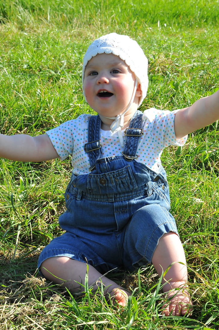 small child, arms raised, meadow, cap, sun
