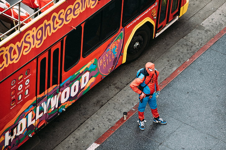 bus, costume, pavement, person, road, spiderman, street