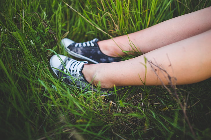 girl, black, sneakers, sitting, green, grass, field
