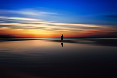 silhouet, man, lichaam, water, kijken naar, zonsondergang, strand