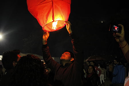 person, holding, red, lantern, outside, nightime, paper