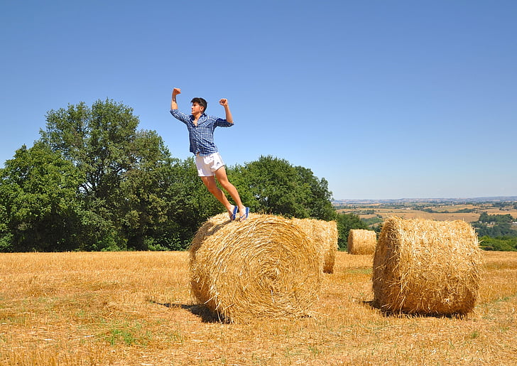 man, white, short, jumping, daytime, hay, field