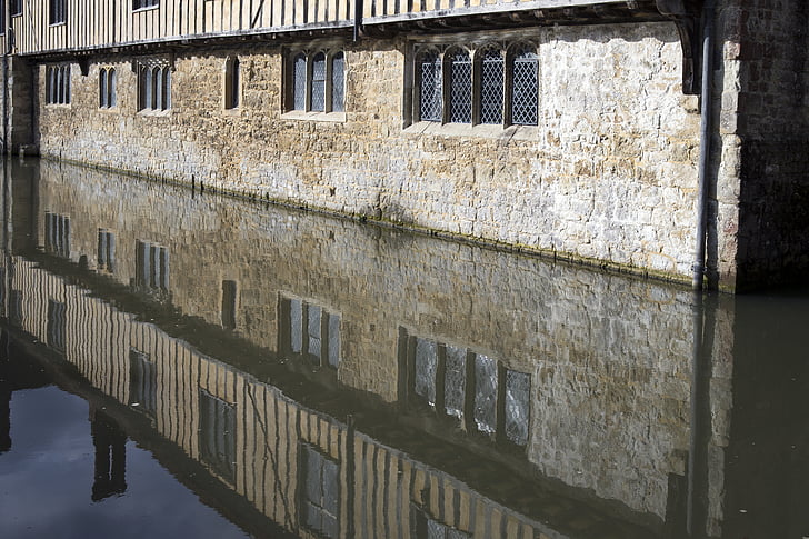 ightham mote, moated manor house, stonework, trefoil stone window frames, leaded lights, lead rainwater pipe, water