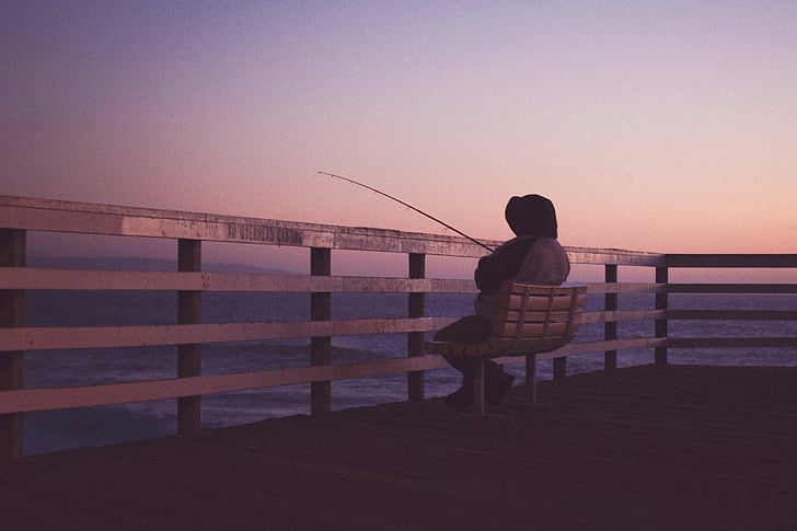person, hooded, jacket, sitting, bench, fishing, twilight