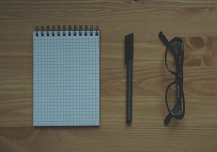 desk, eyeglasses, eyewear, notebook, notepad, pen, table