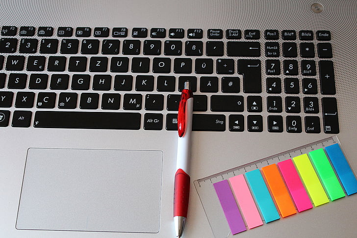 laptop, keyboard, notebook, pen, sticky notes