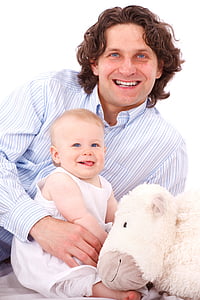 man, smiling, holding, baby, near, plush, toy
