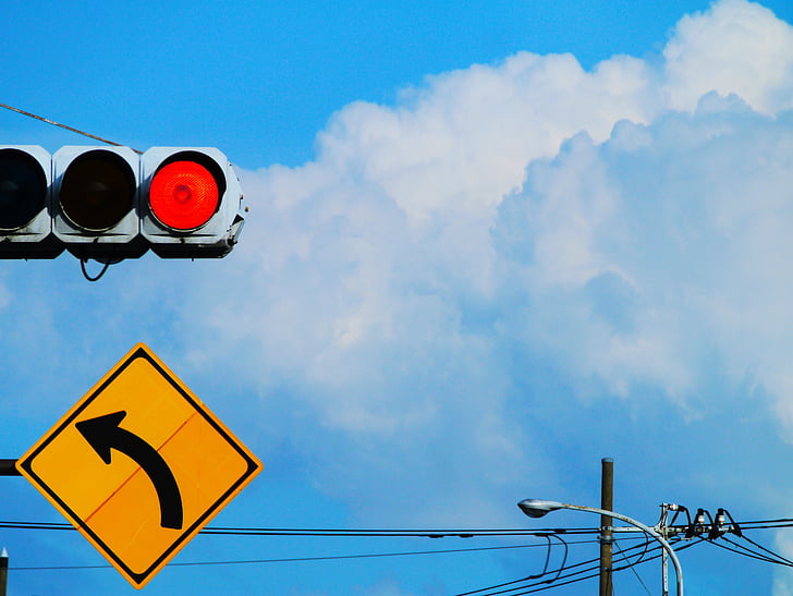 red light, traffic signs, curve, yellow, red, blue sky, towering cumulus clouds observed