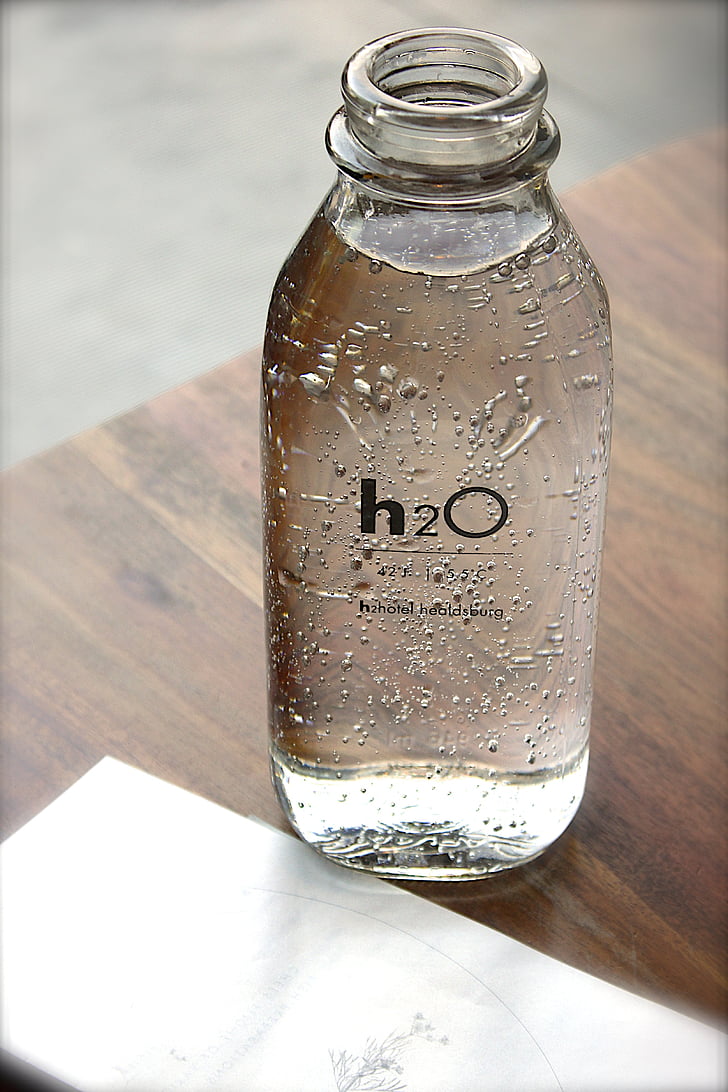 bottle, glass, water, text, table, indoors, liquid