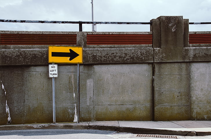 yellow, left, turn, signage, near, concrete, wall