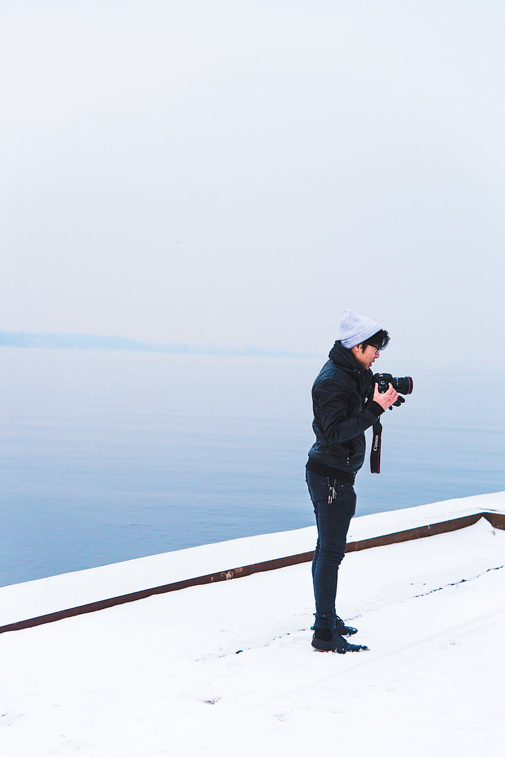 person, holding, dslr, camera, standing, snow, covered