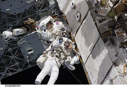 two astronauts, spacewalk, space shuttle, discovery, tools, suit, pack