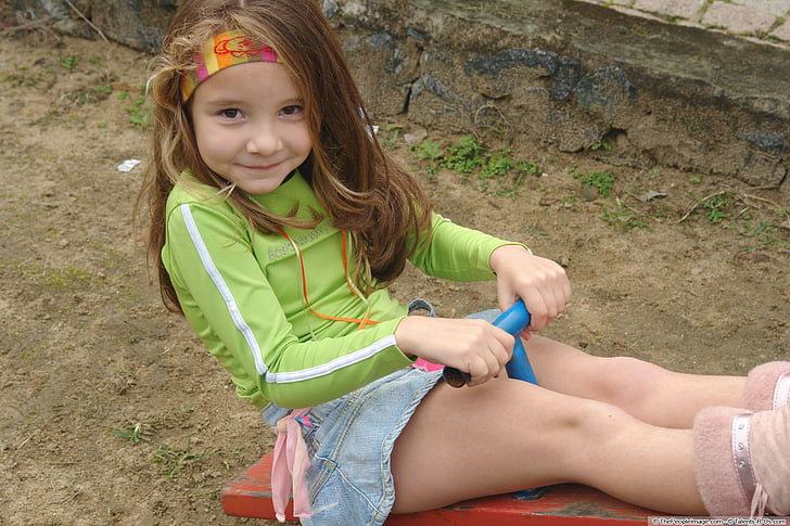 mergina ant sūpynės, džinsinis sijonas, šypsena, vaikų žaidimų aikštelė