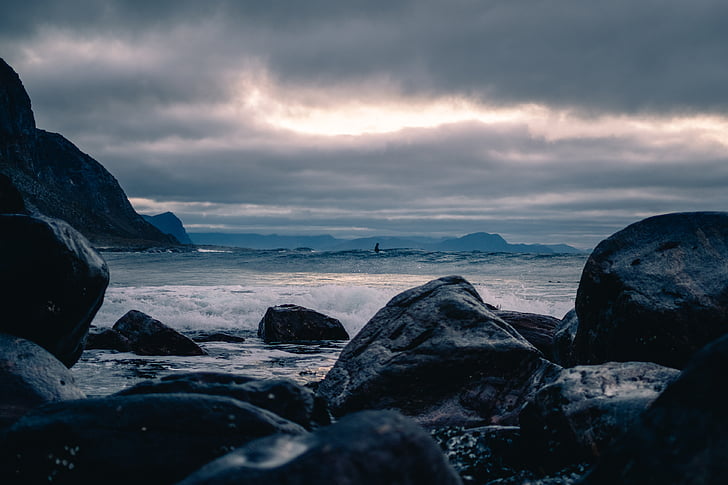 black, rocks, near, beach, daytime, ocean, sea