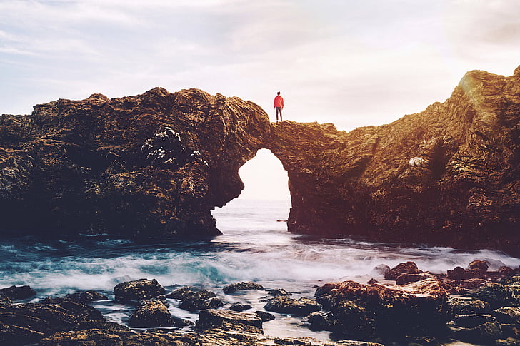 person, standing, rock, formation, shore, sunset, cliff