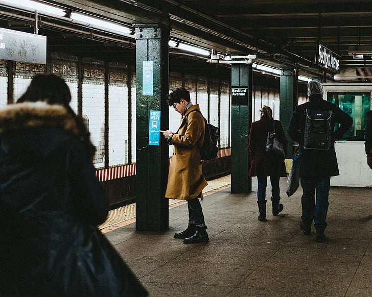 man, brown, coat, holding, phone, subway, station