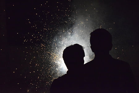 silhueta, dois, pessoa, em pé, parte dianteira, fogos de artifício, à noite