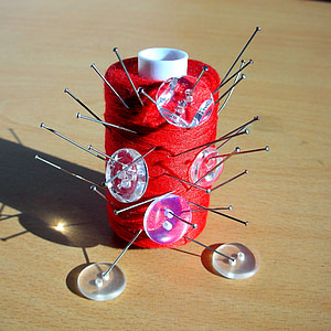 fio vermelho, bobina, agulhas, pinos, botões transparentes, tabela