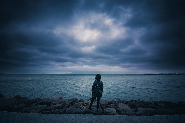 woman, gray, jacket, standing, rocks, beside, sea