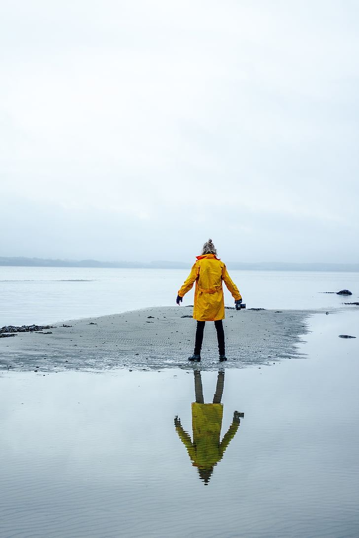 person, yellow, jacket, standing, seashore, daytime, sea