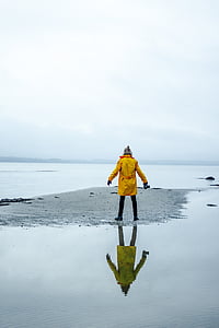 person, yellow, jacket, standing, seashore, daytime, sea
