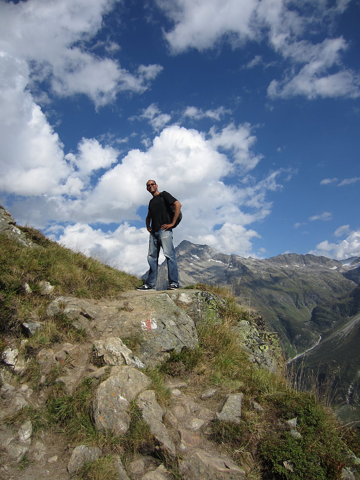 man, top of mountain, alps, switzerland, sunny, white clouds