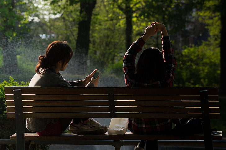 focus, photography, two, women, sitting, bench, near