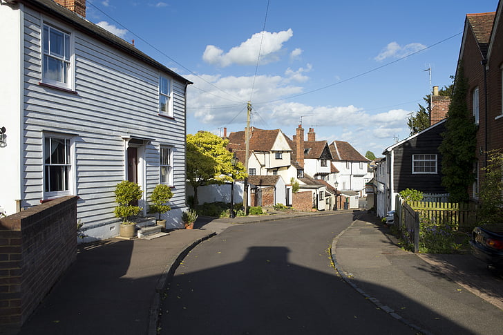 Engels dorp straatbeeld, eclectische architectuur, Telegraaf pole, overhead telefoonlijnen, blauwe hemel
